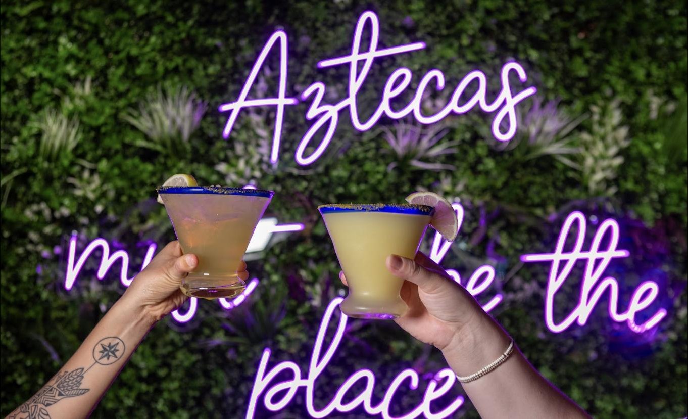 Friends toasting under the neon at the cantina