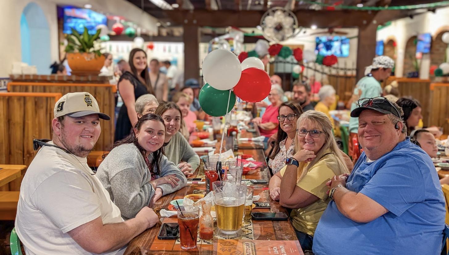 A big party table at Aztecas with balloons and a dozen guests